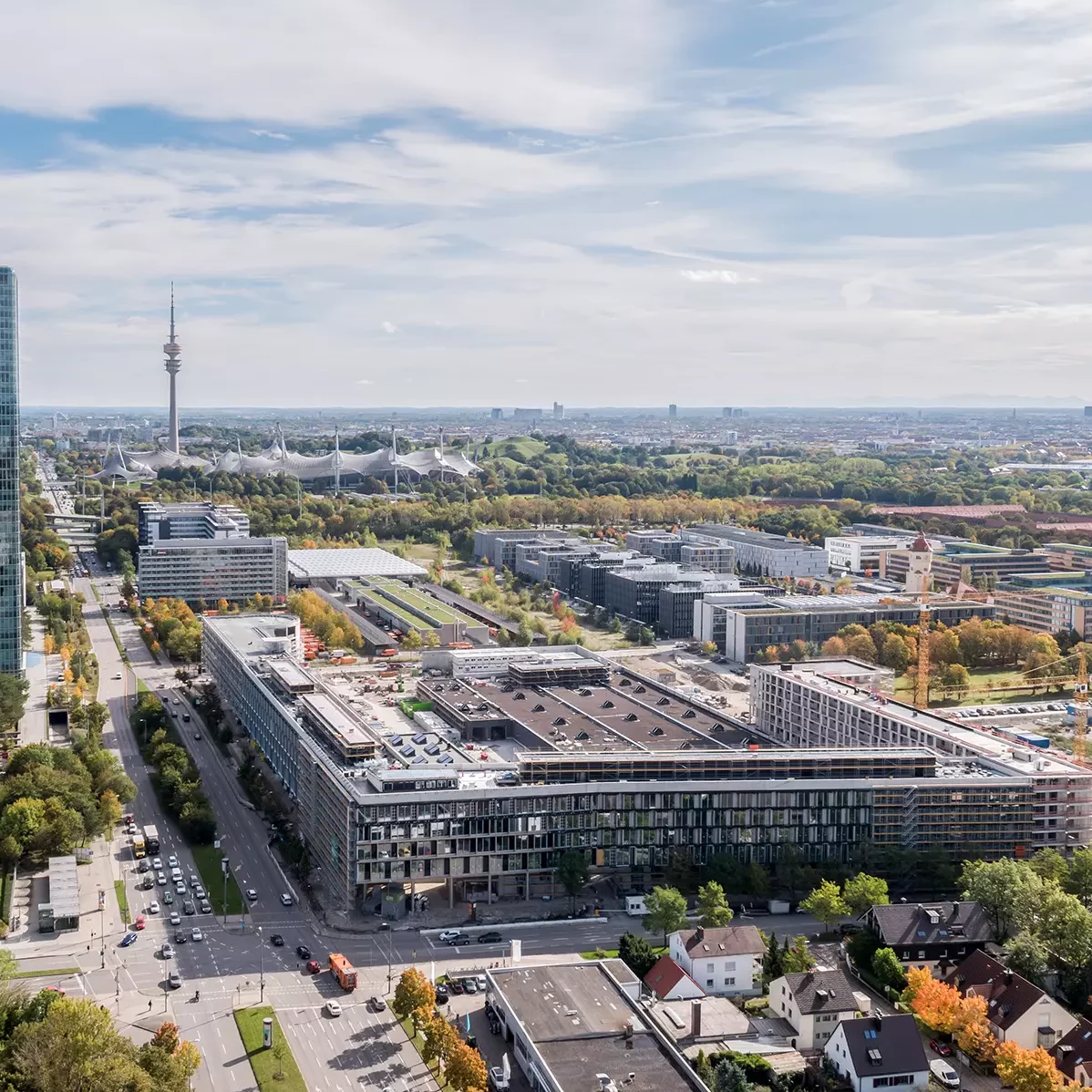 Luftaufnahme des Busbetriebshof mit Hochhaus und Olympiastadion in München