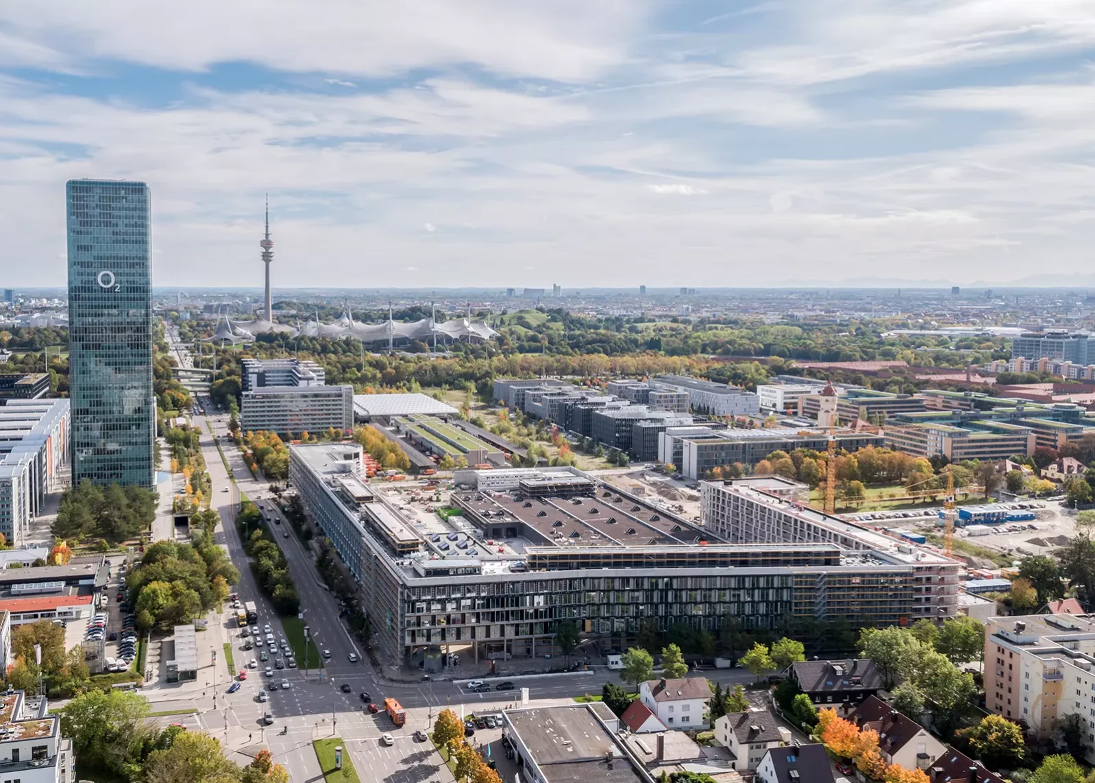 Luftaufnahme des Busbetriebshof mit Hochhaus und Olympiastadion in München