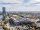 Luftaufnahme des Busbetriebshof mit Hochhaus und Olympiastadion in München