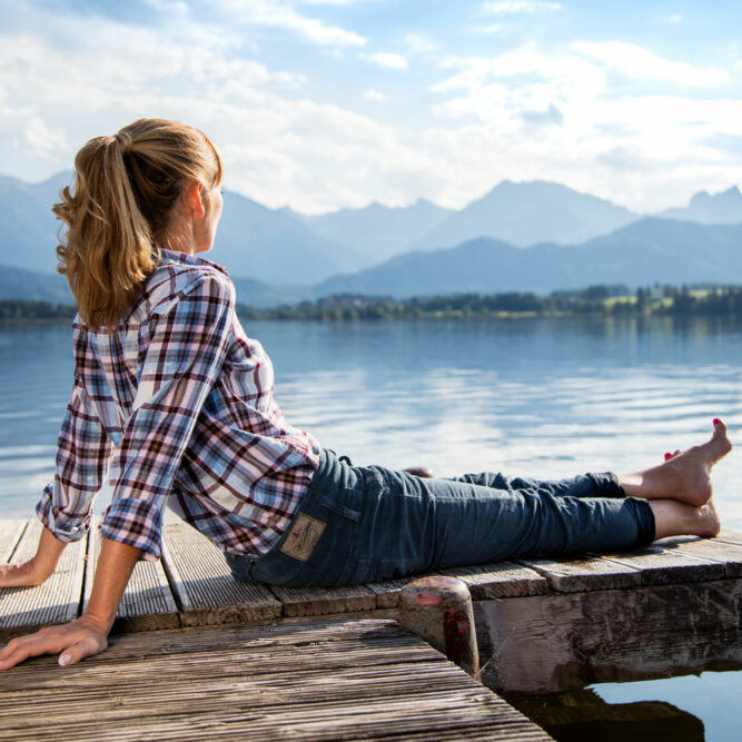 Person auf Steg am Hopfensee im Allgäu